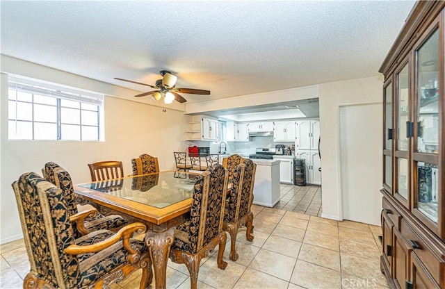 dining room with ceiling fan, sink, a textured ceiling, and light tile patterned floors