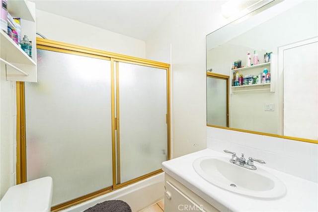 full bathroom with vanity, combined bath / shower with glass door, and toilet