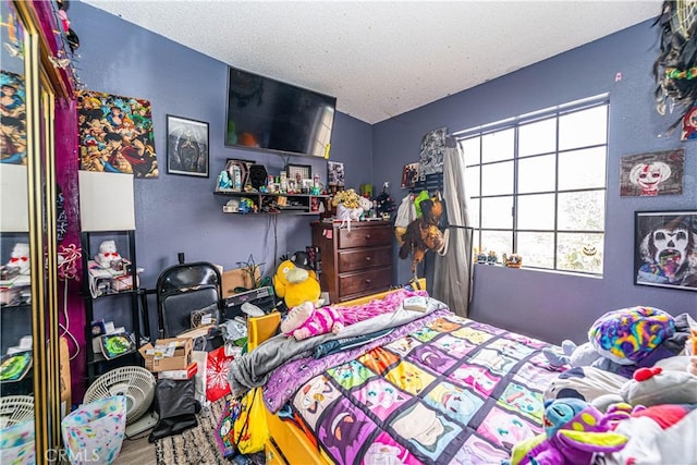 bedroom featuring hardwood / wood-style flooring and a textured ceiling