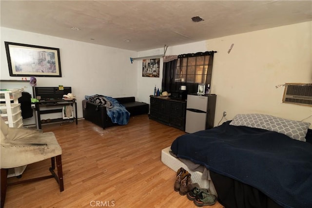 bedroom with refrigerator and wood-type flooring