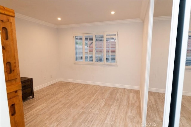 empty room featuring light wood-type flooring and ornamental molding