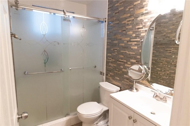 bathroom featuring a shower with shower door, backsplash, toilet, and vanity