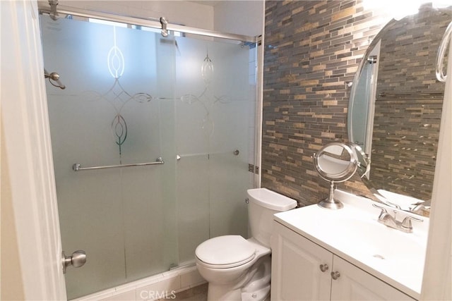 bathroom featuring backsplash, toilet, walk in shower, and vanity