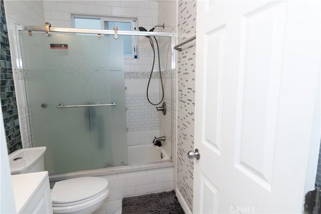 full bathroom featuring toilet, bath / shower combo with glass door, and vanity