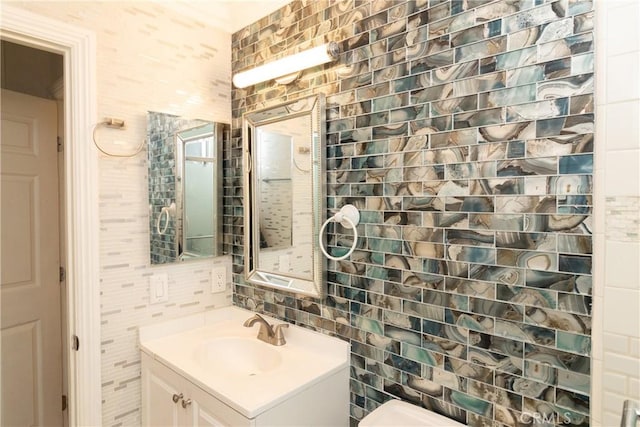 bathroom featuring decorative backsplash, tile walls, toilet, and vanity