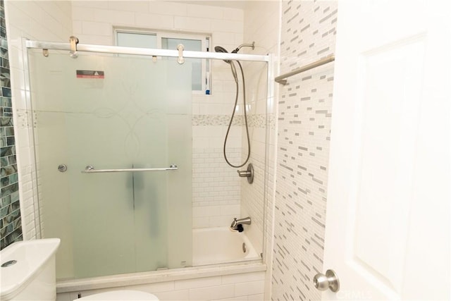 bathroom with shower / bath combination with glass door and toilet