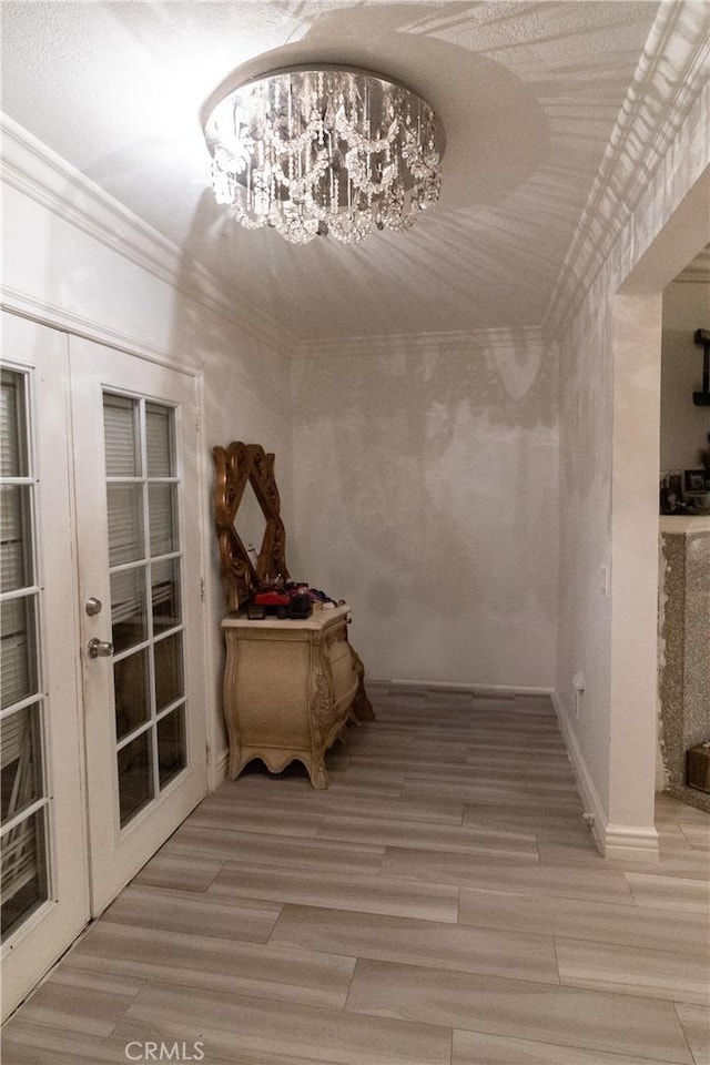 hall featuring french doors, hardwood / wood-style floors, and a notable chandelier