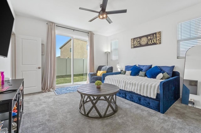 living room with carpet floors, ceiling fan, and a healthy amount of sunlight