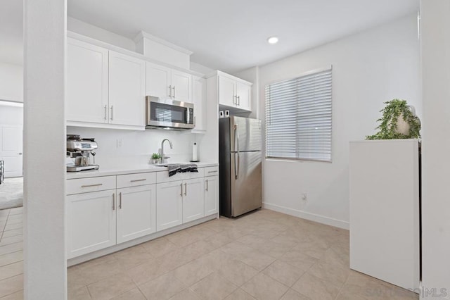 kitchen with sink, white cabinets, stainless steel appliances, and light tile patterned flooring