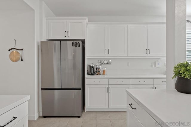 kitchen with light tile patterned floors, white cabinetry, and stainless steel fridge