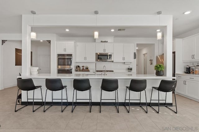 kitchen with a spacious island, hanging light fixtures, and stainless steel appliances