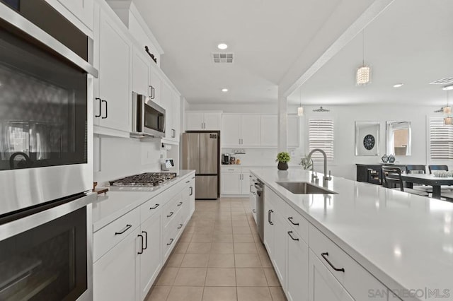 kitchen featuring sink, white cabinets, appliances with stainless steel finishes, and light tile patterned flooring