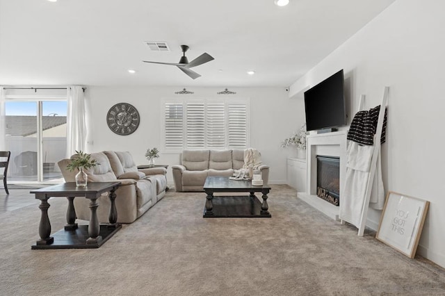 living room with ceiling fan and light colored carpet