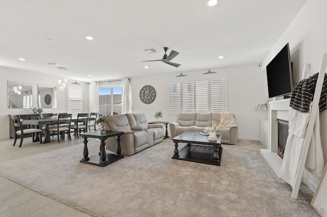 living room featuring ceiling fan, light colored carpet, and plenty of natural light