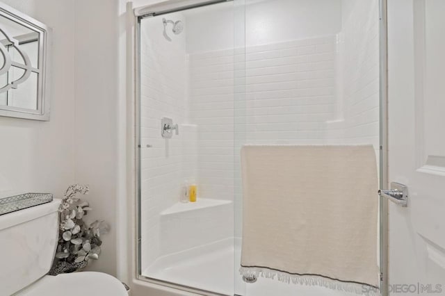 bathroom with toilet and an enclosed shower