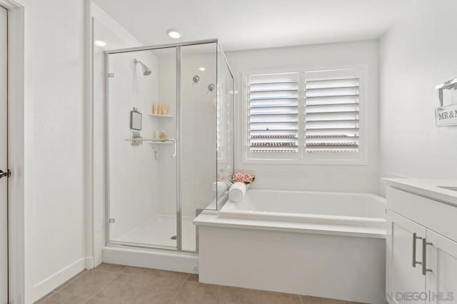 bathroom with tile patterned flooring, vanity, and shower with separate bathtub