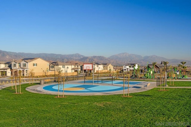 view of home's community featuring a mountain view, a playground, a yard, and basketball hoop