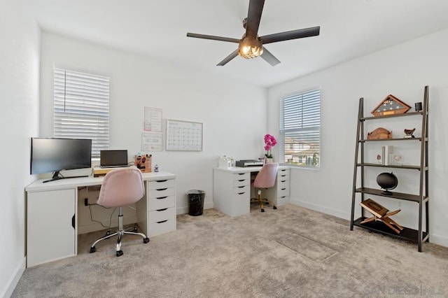 carpeted home office featuring ceiling fan