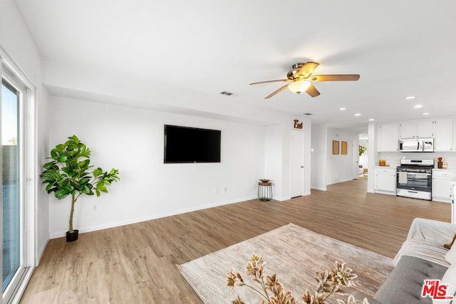 unfurnished living room featuring light hardwood / wood-style floors and ceiling fan