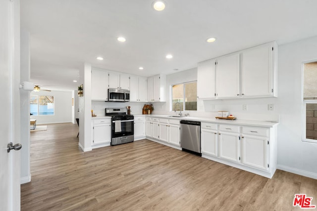 kitchen featuring white cabinetry, ceiling fan, stainless steel appliances, light wood-type flooring, and sink