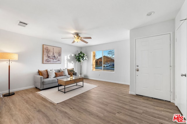 living room with ceiling fan and light hardwood / wood-style flooring