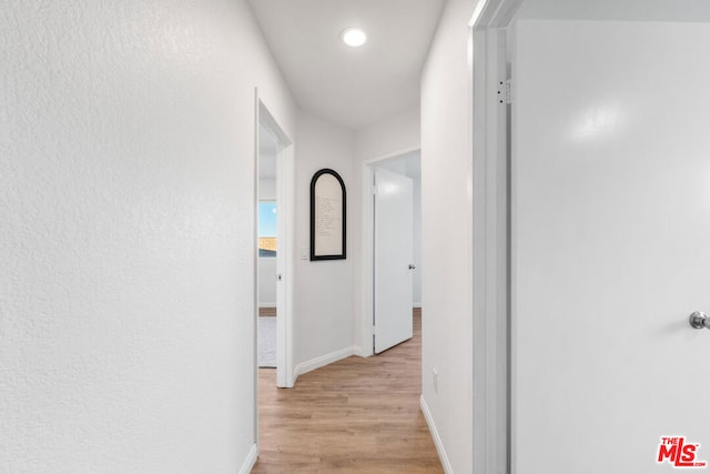 corridor with light hardwood / wood-style floors