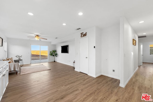 unfurnished living room featuring ceiling fan and hardwood / wood-style floors