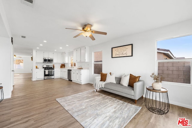 living room featuring ceiling fan and light hardwood / wood-style flooring