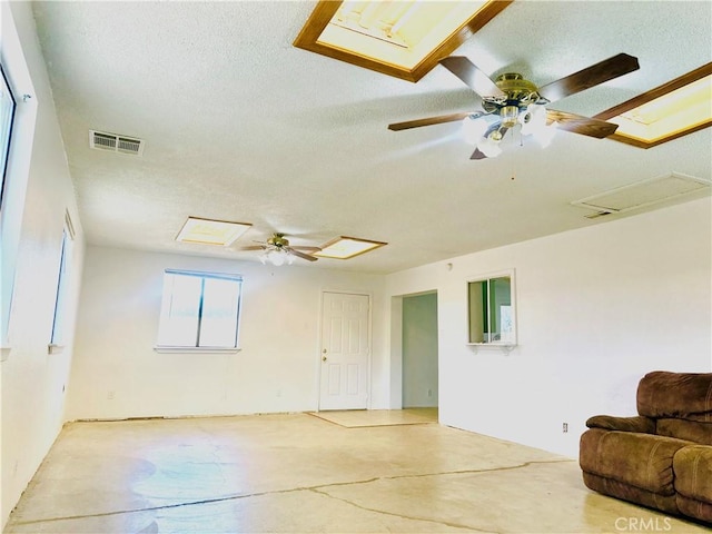 10907 Bartlett, Adelanto, CA 92301 - unfurnished living room featuring a textured ceiling, concrete floors, ceiling fan, and attic access
