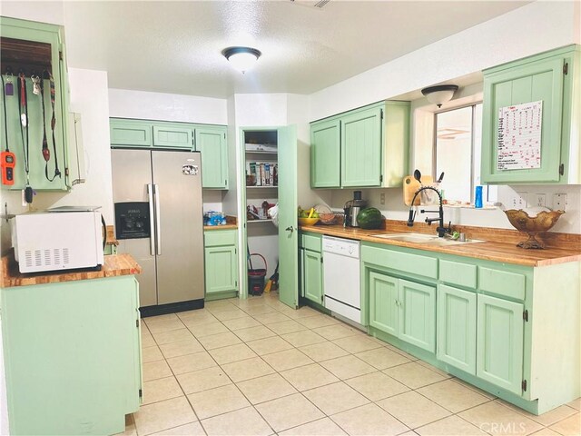 10907 Bartlett, Adelanto, CA 92301 - kitchen featuring white appliances, a sink, light tile patterned floors, green cabinets, and wooden counters
