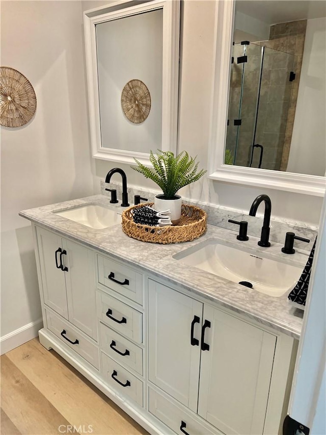 bathroom with vanity, hardwood / wood-style floors, and a shower with door