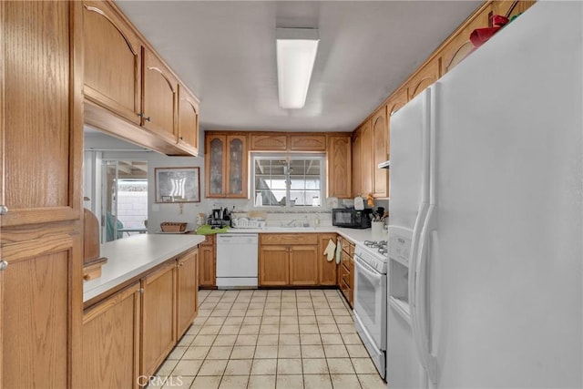 kitchen with sink, white appliances, and plenty of natural light