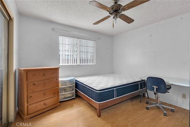 bedroom with ceiling fan, a textured ceiling, and light hardwood / wood-style flooring