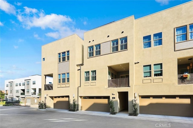 view of building exterior with an attached garage and a residential view