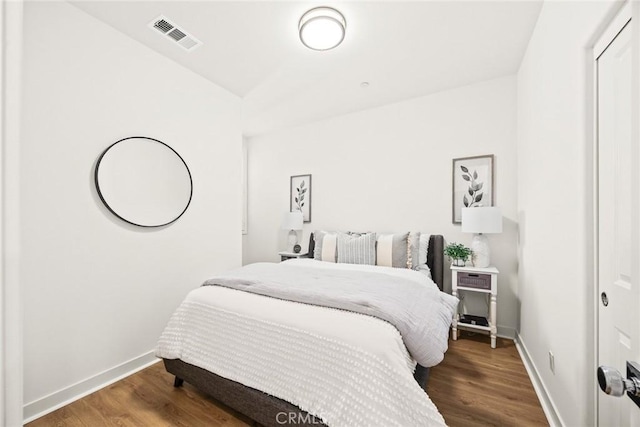 bedroom featuring visible vents, baseboards, and wood finished floors