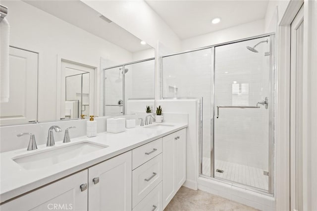 bathroom featuring walk in shower, vanity, and tile patterned flooring