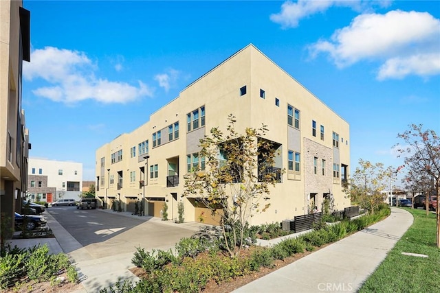 view of building exterior featuring a residential view and central AC unit