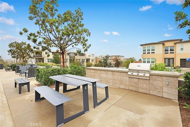 view of patio / terrace with exterior kitchen, a residential view, and a grill