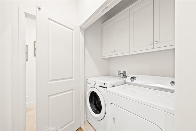 laundry area featuring washer and clothes dryer and cabinets