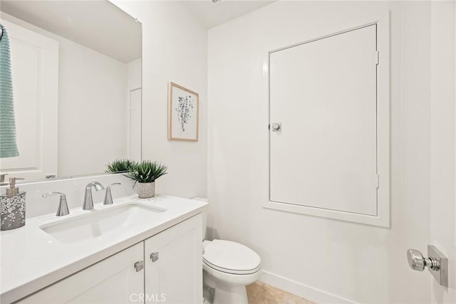 half bathroom with tile patterned floors, toilet, and vanity