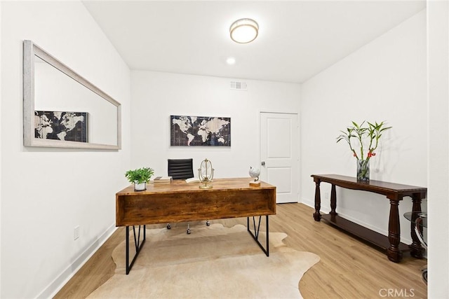 office area with wood finished floors, visible vents, and baseboards