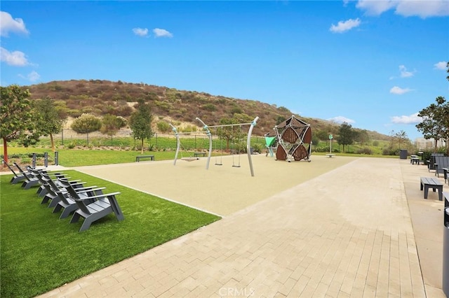 view of jungle gym featuring a mountain view and a lawn