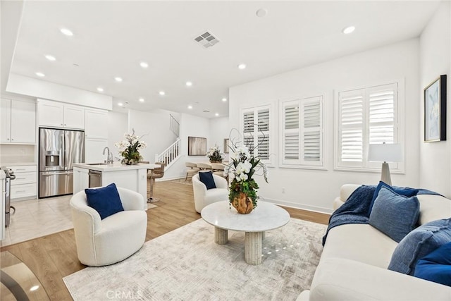 living room with light hardwood / wood-style floors and sink