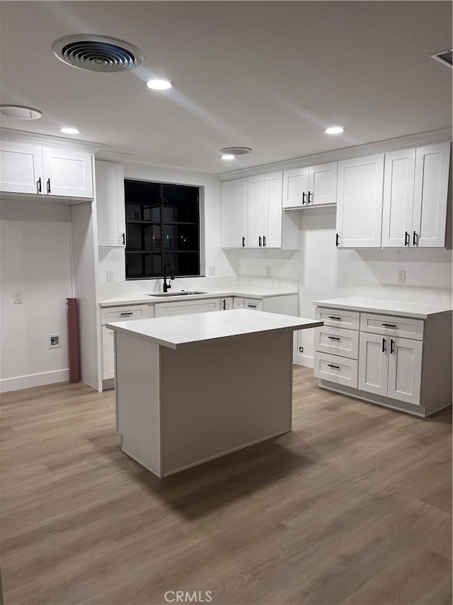 kitchen featuring white cabinetry, a kitchen island, and sink