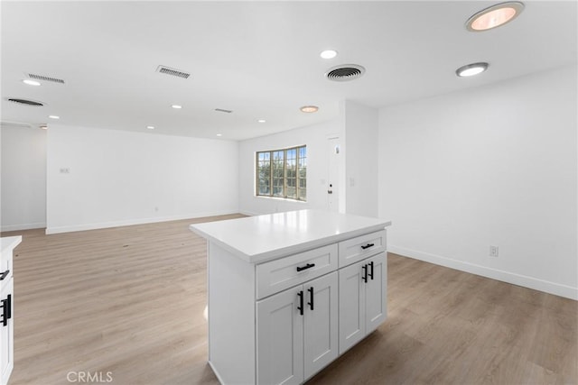 interior space featuring white cabinetry, light wood-type flooring, and a kitchen island