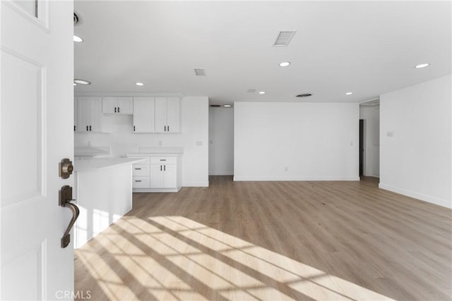 kitchen with light hardwood / wood-style flooring and white cabinets