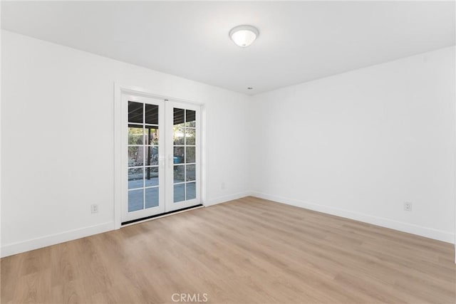 empty room with french doors and light hardwood / wood-style floors