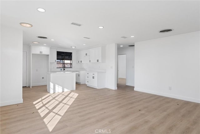 unfurnished living room with light hardwood / wood-style floors and sink