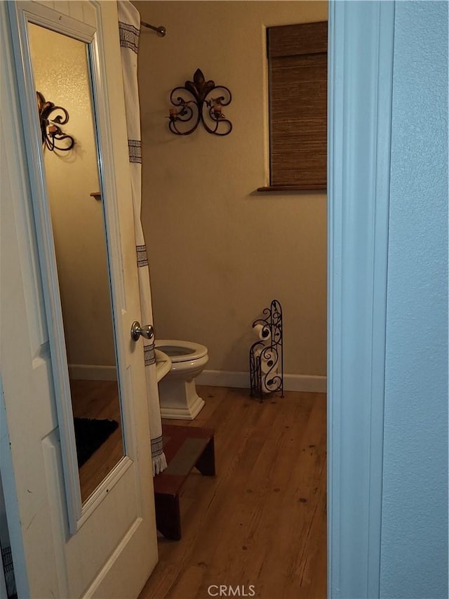 bathroom with toilet and wood-type flooring