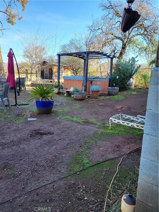 view of yard featuring a hot tub and a pergola